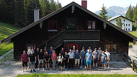 TQ-Berghütte mit Mitarbeitern davor 