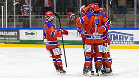 Mehrere Eishockey Spieler umarmen sich auf dem Eis