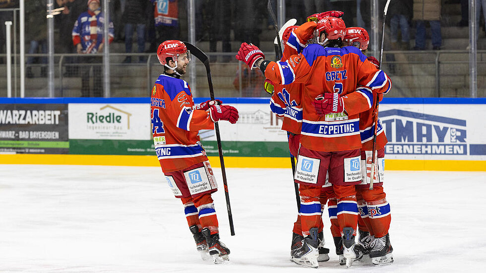 Mehrere Eishockey Spieler umarmen sich auf dem Eis
