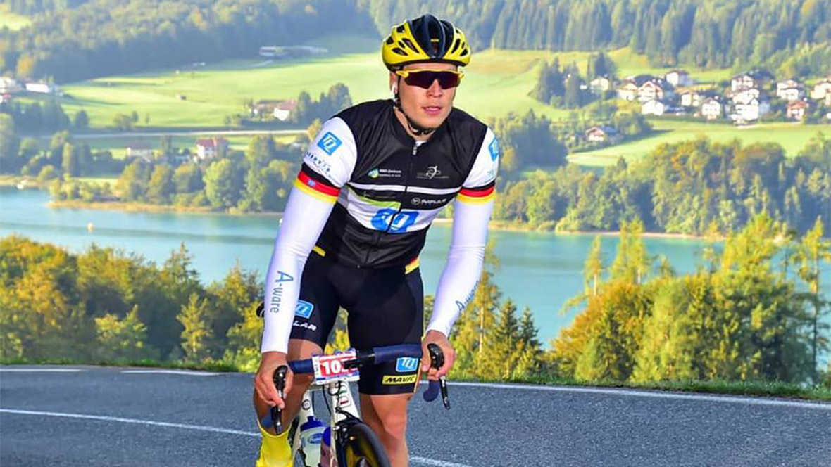 Profiradfahrer Alexander Steffens auf einem Rennrad im Hintergrund ein Bergsee